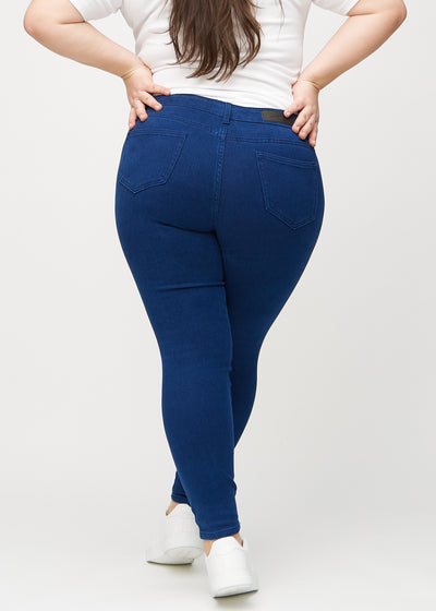 Mørkeblå skinny jeans set bagfra på en plus-size model, så man kan se hele produktet.