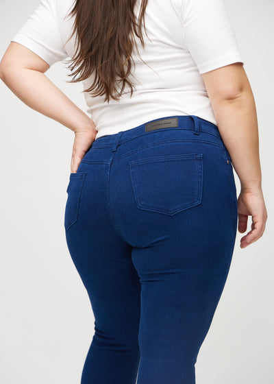 Mørkeblå skinny jeans set bagfra tæt på en plus-size model for at vise detaljer.