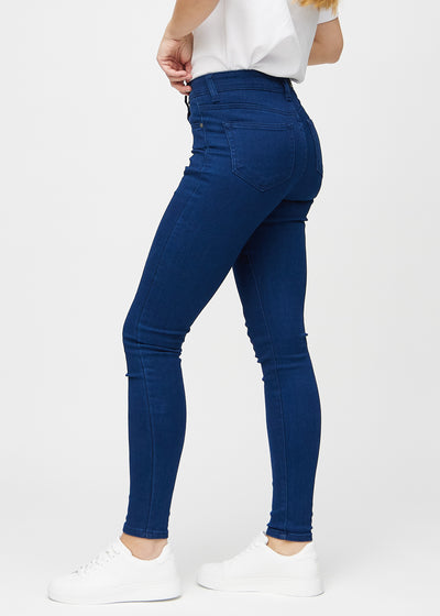 Mørkeblå skinny jeans set fra siden på model.